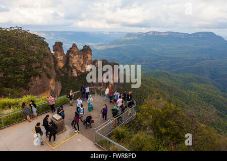 Tourists enjoying the view of the famous Three Sisters rock formation from Echo Point Lookout. Katoomba, New South Wales, Austra Stock Photo