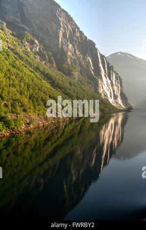 Waterfall reflections in a Norwegian fjord, early morning on Midsummer's Day. Stock Photo