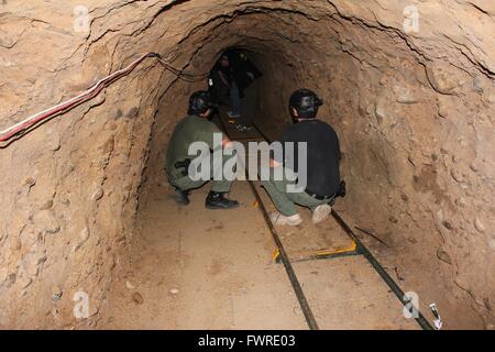 U.S Border Patrol officers examine a tunnel used for smuggling operations between Tijuana and San Diego November 29, 2011 at Otay Mesa, California. The tunnel is a half mile long and featured ventilation, lighting and a rail system capable of moving loads of wrapped marijuana across the border. Stock Photo