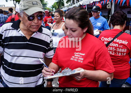 Miami Florida,Little Havana,Calle Ocho,annual street festival,Hispanic adult adults,woman female women,man men male,survey,filling out questionnaire,c Stock Photo