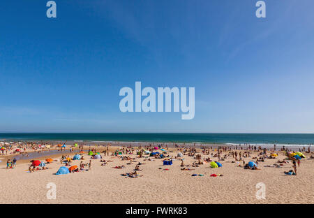 Crowded Atlantic summer beach in Carcavelos town, Portugal Stock Photo