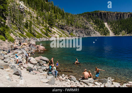 Tourists swimming in the crystal clear water of Crater Lake.  Crater Lake National Park, Oregon Stock Photo