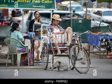 Rickshaw driver relaxing, Yangon, Myanmar Stock Photo