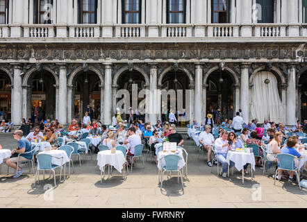 Tourists seated outside of Caffe Aurora in St Mark's Square, San Marco, Venice, Italy Stock Photo