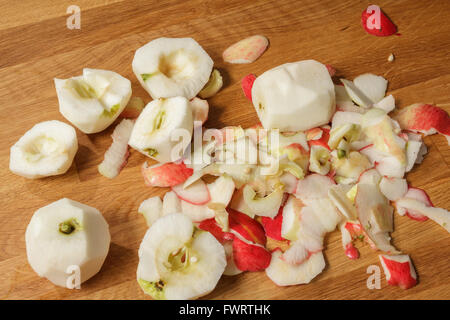 Pile of peeled apples and apple peel on a wooden table Stock Photo