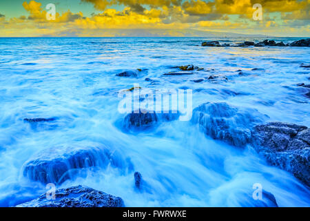 waves on beach in Maui at dawn with distant view of Molokai Hawaii Stock Photo