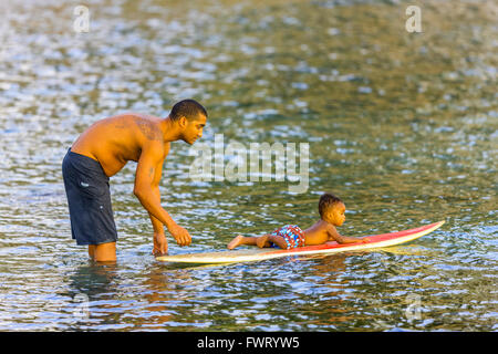 father giving son surf lessons, Maui Stock Photo