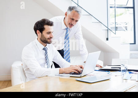 Businessmen discussing office work on laptop Stock Photo