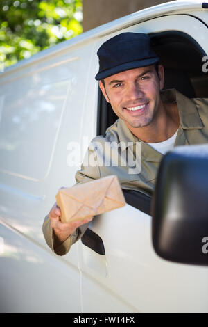Smiling delivery man sitting in his van Stock Photo