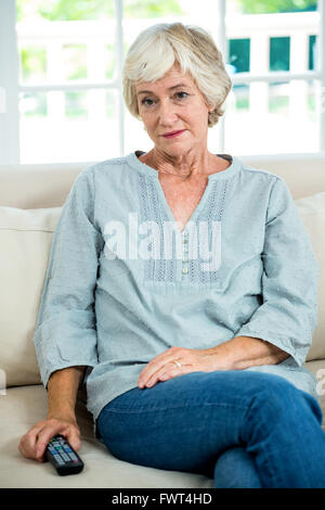 Thoughtful senior woman sitting on sofa Stock Photo