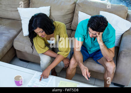 Worried young couple discussing on bills Stock Photo