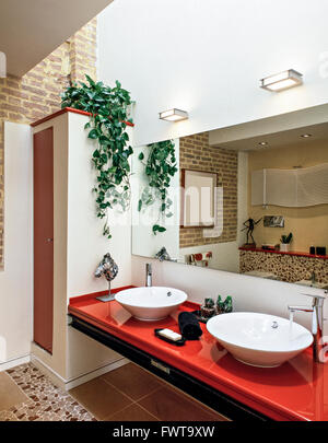 foreground of a red worktop with two washbasin  in a modern bathroom Stock Photo