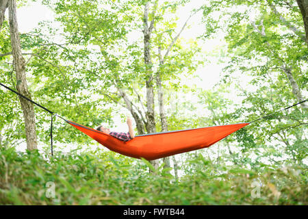 Caucasian man on a hammock at a camp site Stock Photo