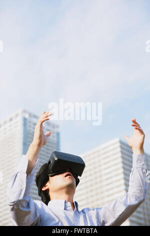 Japanese man using virtual reality device Stock Photo