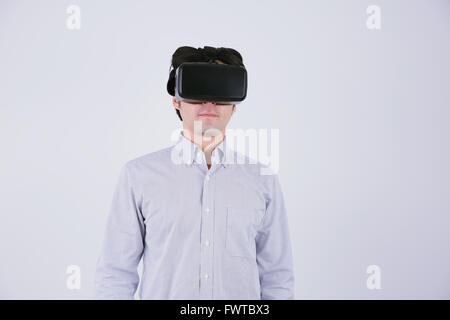 Japanese man using virtual reality device Stock Photo