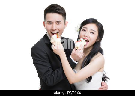 Happy bride and groom eating cake Stock Photo