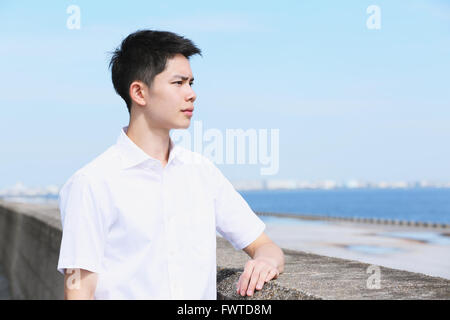 Portrait of young Japanese man by the sea Stock Photo