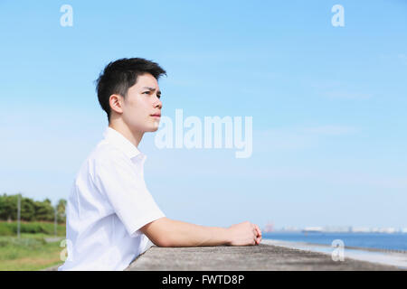 Portrait of young Japanese man by the sea Stock Photo