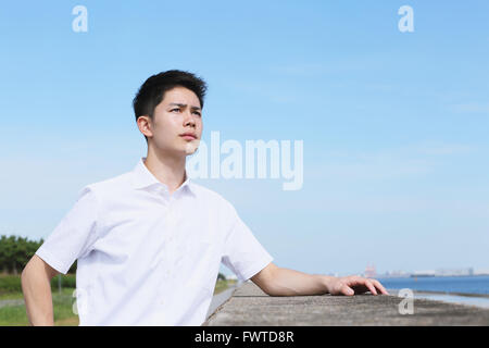 Portrait of young Japanese man by the sea Stock Photo