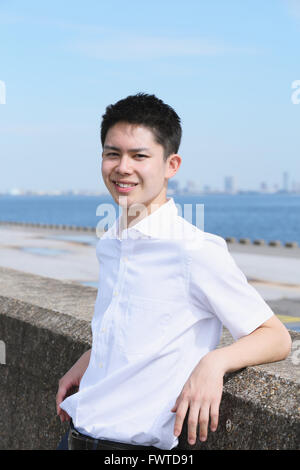 Portrait of young Japanese man by the sea Stock Photo