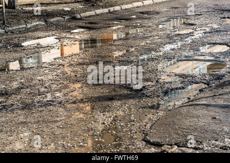 Potholes on asphalt road filled with water Stock Photo