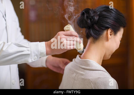 Senior Chinese doctor giving moxibustion Stock Photo