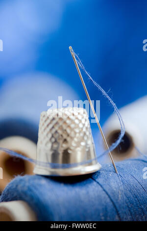 needle with blue thread on the blue background Stock Photo