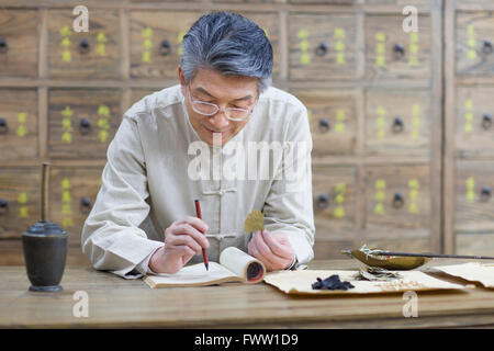 Senior Chinese doctor checking medicinal herbs Stock Photo