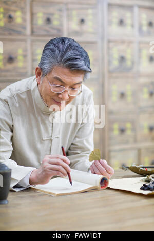 Senior Chinese doctor checking medicinal herbs Stock Photo