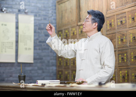 Senior Chinese doctor checking medicinal herbs Stock Photo