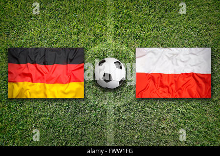 Germany vs. Poland flags on green soccer field Stock Photo