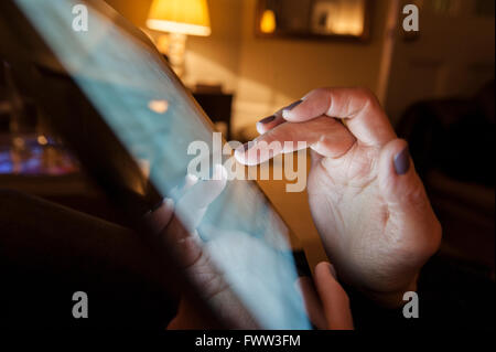 A woman types on her tablet pc Stock Photo