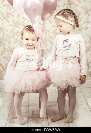 two little girls sisters,in a room with balloons, Stock Photo