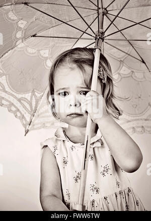 small crying girl holding umbrella Stock Photo