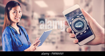 Composite image of asian nurse using tablet Stock Photo
