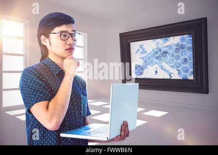 Composite image of thoughtful hipster using his laptop Stock Photo