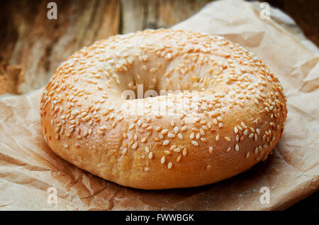 Sesame bagel in paper bag on wooden table Stock Photo