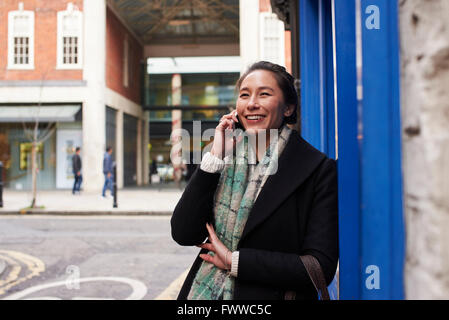 Young Woman Making Phone Call In City Street Stock Photo