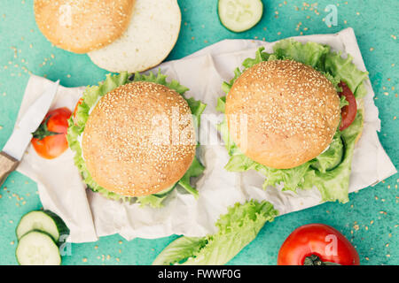 Appetizing burgers on green background Stock Photo