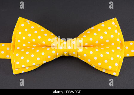 Yellow bow tie on black table Stock Photo