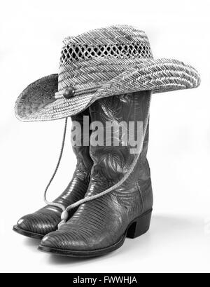Cowboy boots and straw hat in black and white. Stock Photo