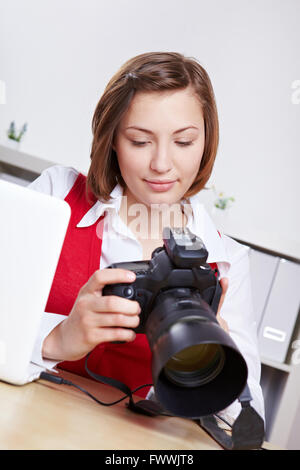 Female photographer in studio checking images on DSLR camera display Stock Photo