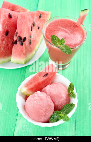 Watermelon ice cream, smoothie and slices on green wooden background Stock Photo