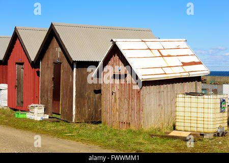 Simrishamn, Sweden - April 1, 2016: Brown and red fishing cabins with metal roofs. These sheds are numbered in the same way that Stock Photo