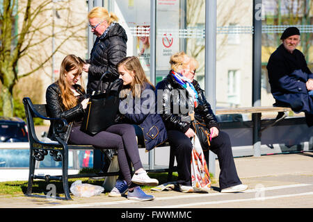 Simrishamn, Sweden - April 1, 2016: People waiting for a bus outside a bus shelter. Real people in everyday life. Stock Photo