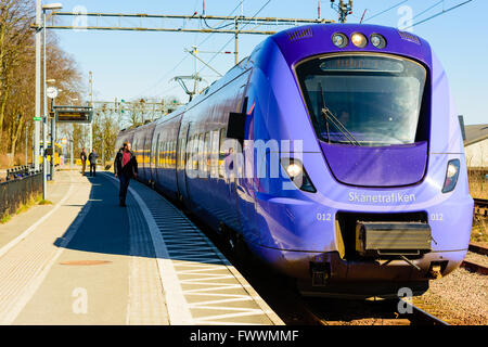 Simrishamn, Sweden - April 1, 2016: Purple train from Skanetrafiken standing by the platform at the railway station in town. Man Stock Photo