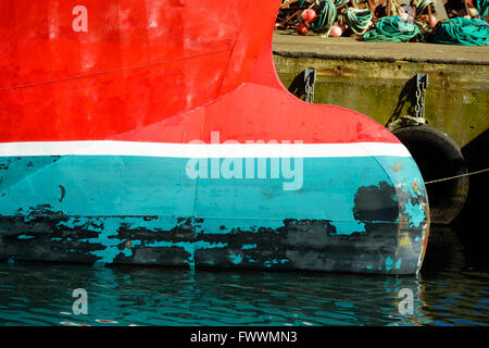 Bulbous bow on the fore of a trawler fishing boat moored at the docks. Red, white and green  are dominating colors. Stock Photo