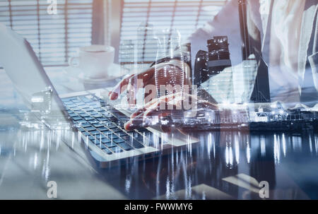 working on laptop, close up of hands of business man, double exposure Stock Photo