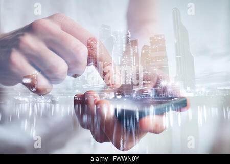 man hands touching smartphone, closeup, double exposure with modern city skyline Stock Photo