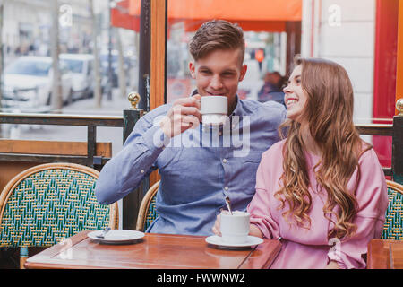 young happy couple drinking coffee and laughing in cafe in Europe, dating, good positive moments Stock Photo
